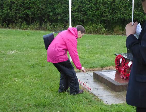 Suzanne places a cross for Munroe Atchley, firefighter